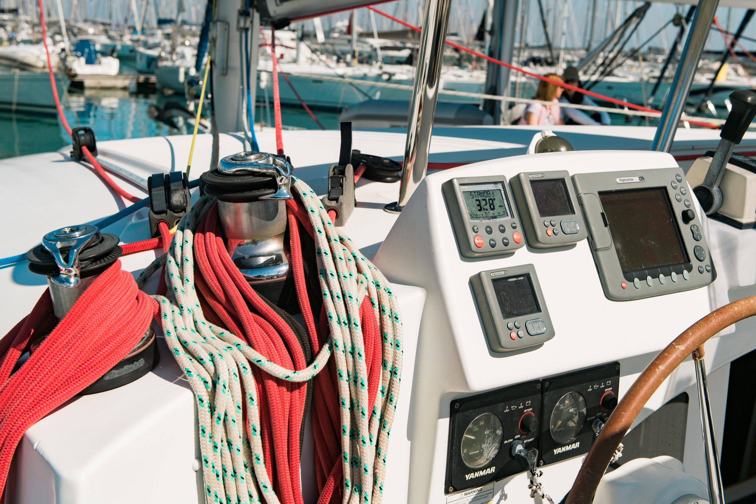 A boat's control panel with various instruments and a steering wheel.