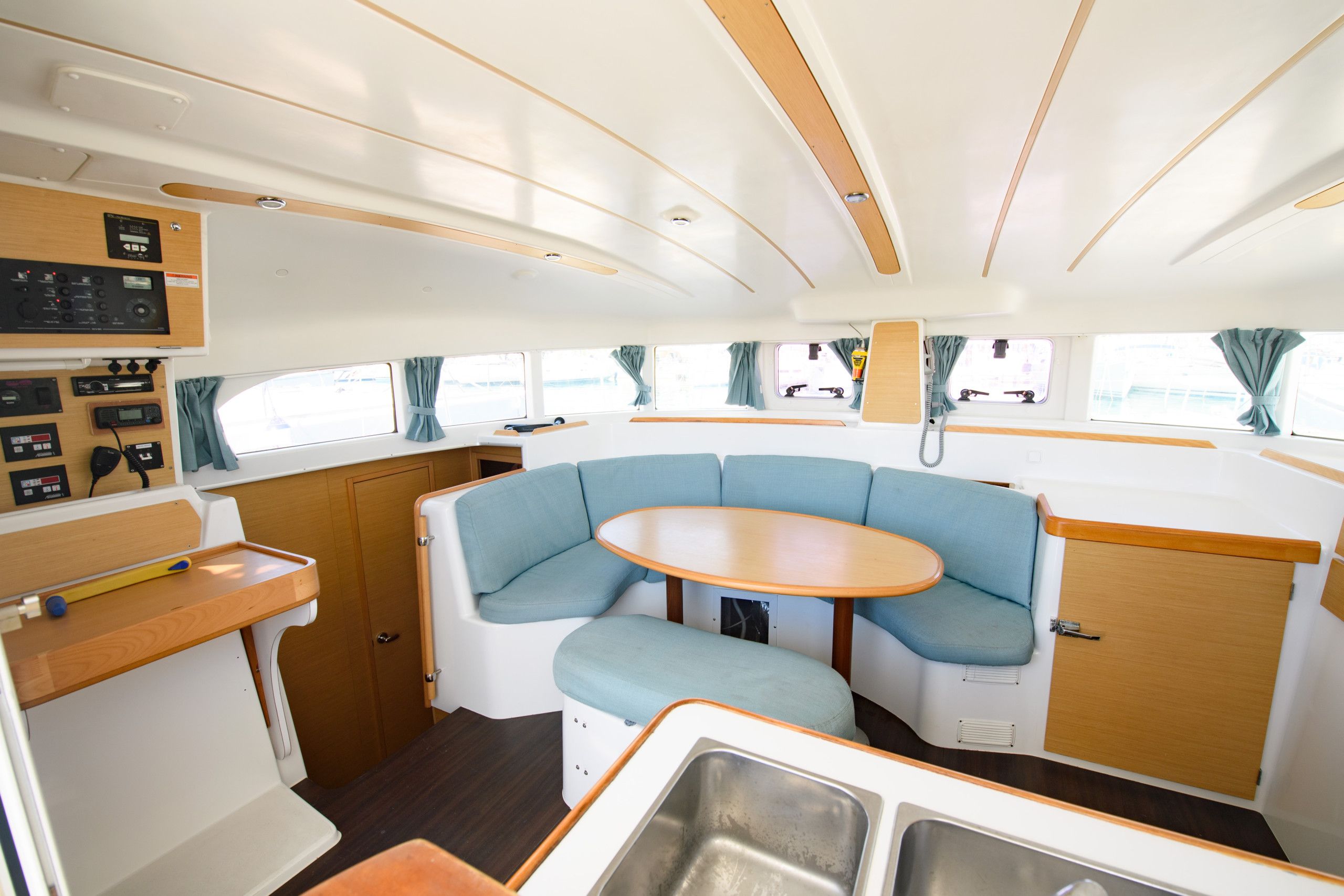 A compact interior with a curved seating area, a small table, and a kitchenette.