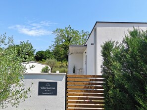 Eine Villa namens 'Villa Sunrise' mit einem Schild, das eine Bewertung von 67 C anzeigt.