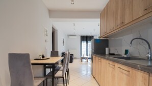 A modern kitchen with wooden cabinets, a black countertop, and a stainless steel sink. - V & G Apartment by Rentals Pro - Nea Moudania (Nea Moudania)