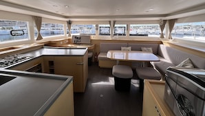 A compact galley with a stove, a small sink, and a control panel.