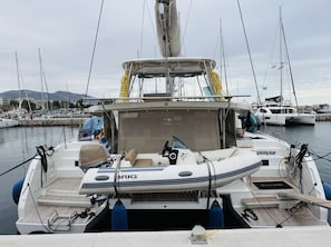 Ein Boot liegt in einer Marina festgemacht, mit einer Kabine, einem Steuer und einem Schild mit der Aufschrift 'BRIG'.