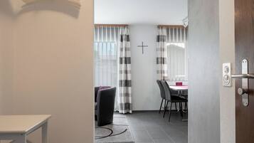 Un intérieur moderne comprenant un coin repas, un porte-manteau et une porte donnant sur une autre pièce.
