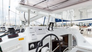 A boat's control station with a steering wheel, gauges, and a cushioned seat. - Sun-Kissed Sailing Adventure in Islas Sarónicas (Alimos)