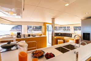 A modern kitchen with a stove, sink, and breakfast items on the counter. - Sun-kissed Sailing Adventure in the Ionian Islands (Preveza)