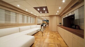 A modern interior with a sofa, a TV, and a dining area. - Sun-Kissed Sailing Adventure in Zadar, Croatia (Drage)