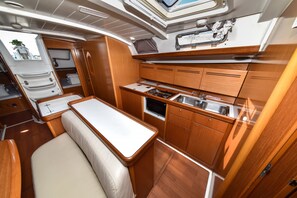 A compact galley with a sink, stove, and storage cabinets. - Sun-Kissed Sailing Adventure in Zadar, Croatia (Bibinje)