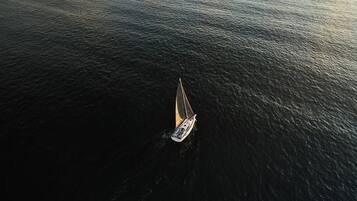 Vue aérienne d’un voilier sur une eau calme.