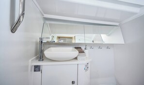 A bathroom with a white sink, chrome faucet, and a mirror above.