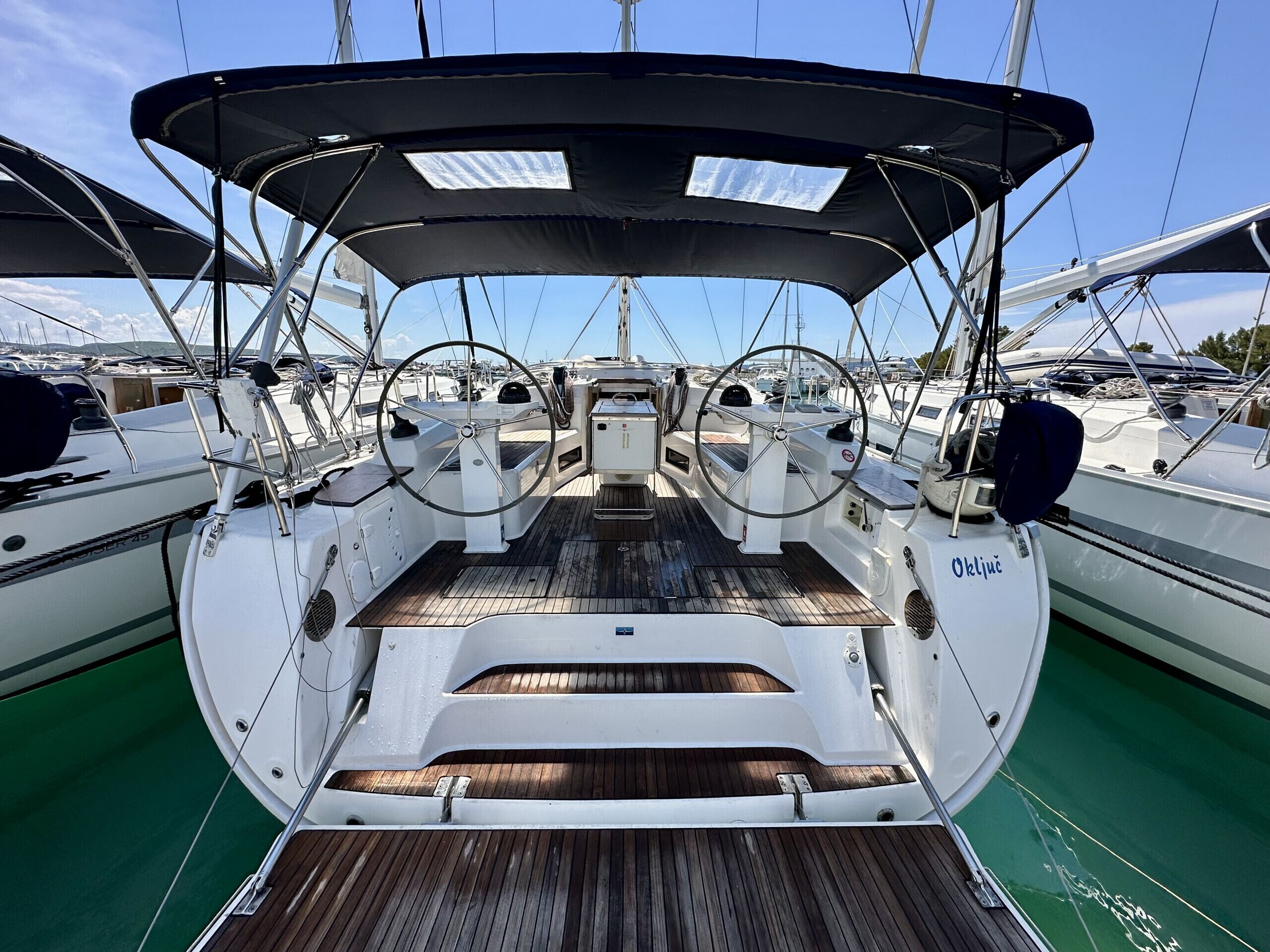 Ein Bootsdeck mit Steuer, Bedienfeld und Sitzgelegenheit.