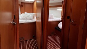 Une cabine compacte comprenant deux lits, un petit coin salon et une fenêtre avec vue.