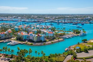 Puerto deportivo con barcos, un puente y un complejo turístico con edificios coloridos.
