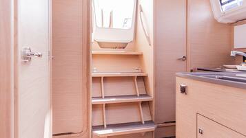 Une cuisine compacte avec des meubles en bois, une étagère intégrée et une fenêtre au-dessus de l’évier.