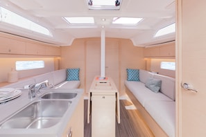 A compact kitchen with a sink, a small table, and a sofa. - Sun-Kissed Sailing Adventure in the Ionian Islands, Lefkada (Lefkada)