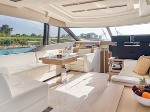A yacht interior with a dining area, seating, a TV, and a view of the sea. - Sun-kissed Sailing Adventure in Split-Dalmatia, Croatia (Trogir)