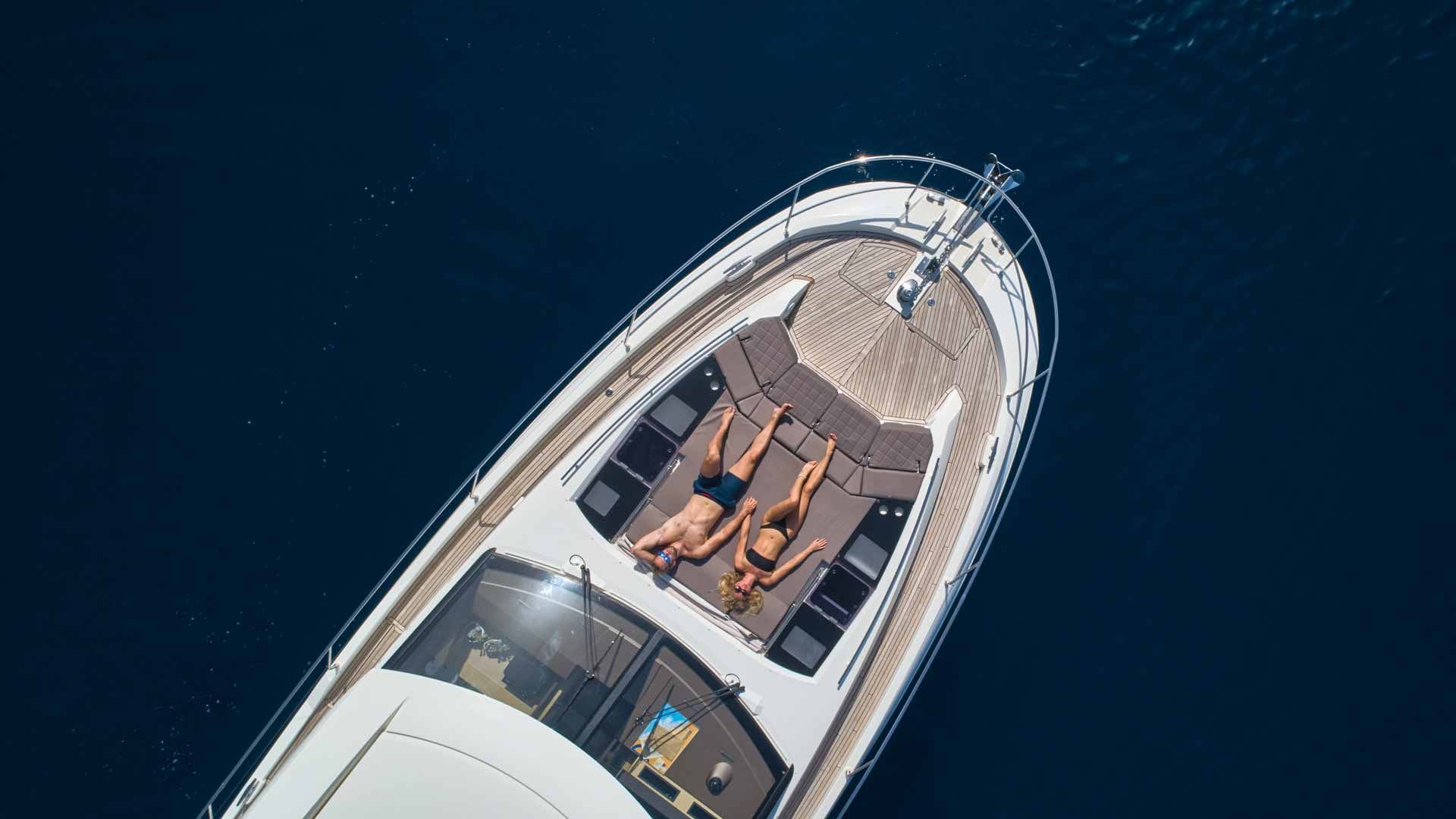 Un barco con zona de cubierta que incluye una disposición de asientos y una cabina de control.