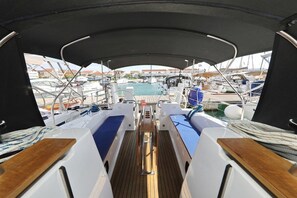 A boat deck with a central walkway, seating areas, and a view of the marina. - Sibenik Sun-soaked Sailing: A Luxurious Croatian Voyage (Pirovac)