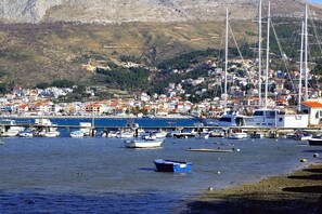 A coastal town with boats docked along the waterfront, a marina, and buildings with red-tiled roofs. - Sun-Kissed Sailing Adventure in Split-Dalmacia, Croatia (Podstrana)