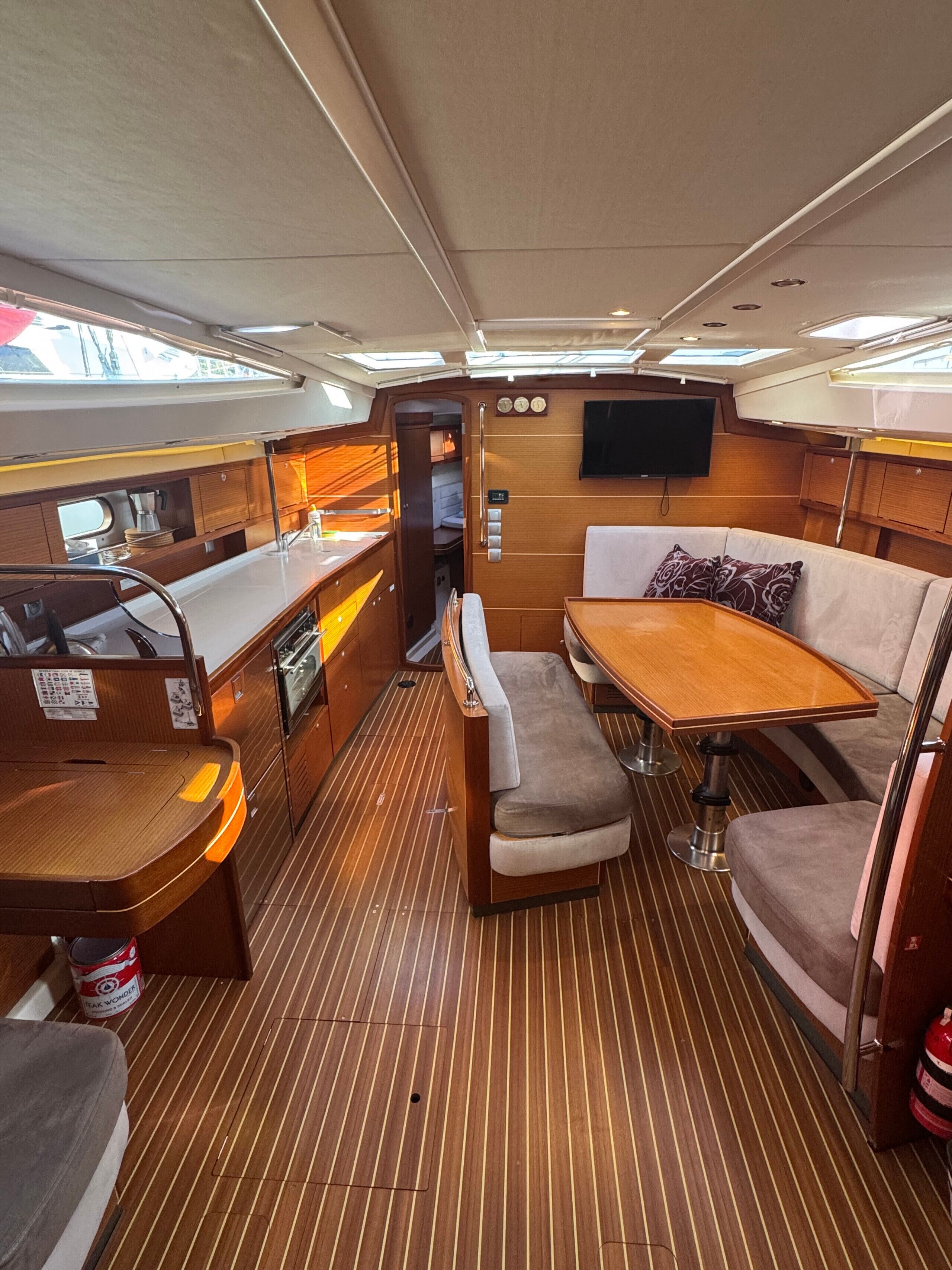 A compact galley with a wooden table, bench seating, and a small kitchenette.