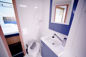A compact bathroom with a toilet, sink, and shower. - Sun-Kissed Sailing Adventure in the Ionian Islands, Lefkada (Lefkada)