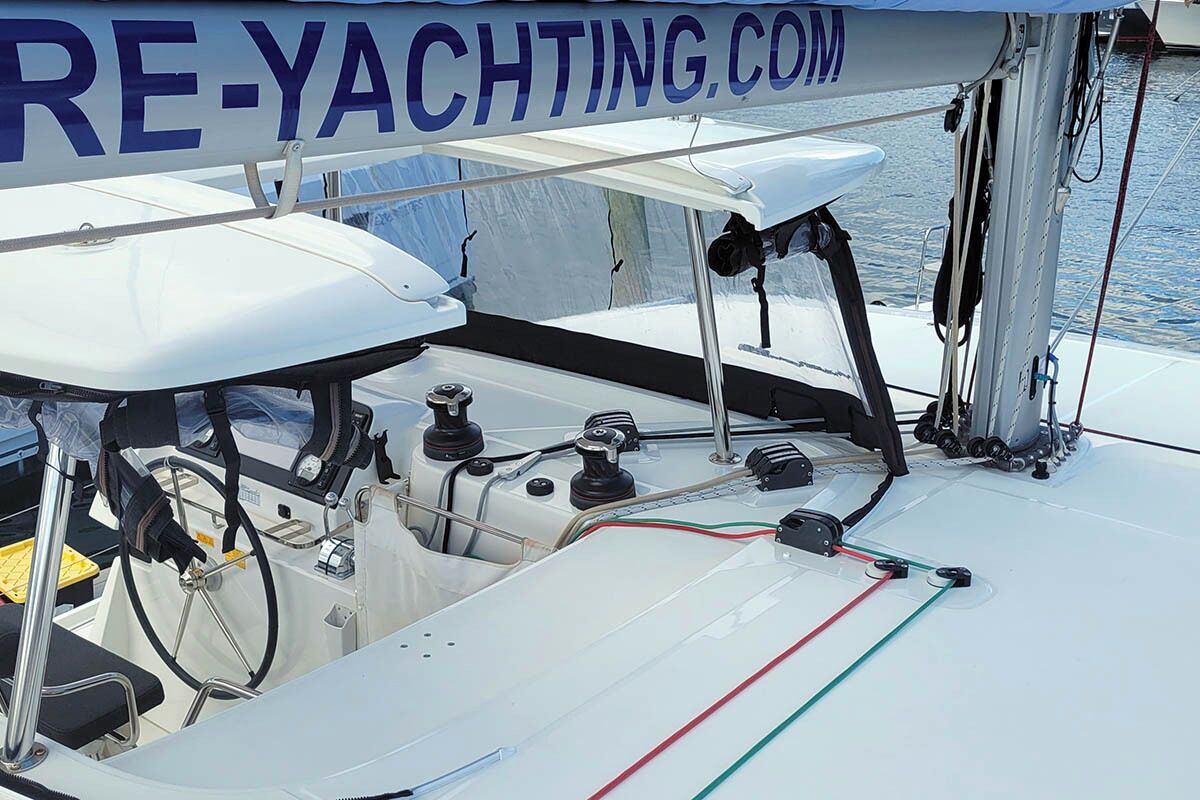 Le pont d’un yacht, avec un volant, des panneaux de contrôle et une bannière de site web.