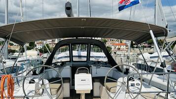 Un pont de bateau équipé d’un volant, d’un panneau de commande et d’un drapeau.