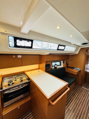 A compact galley with a stove, a small sink, and a window above the counter.