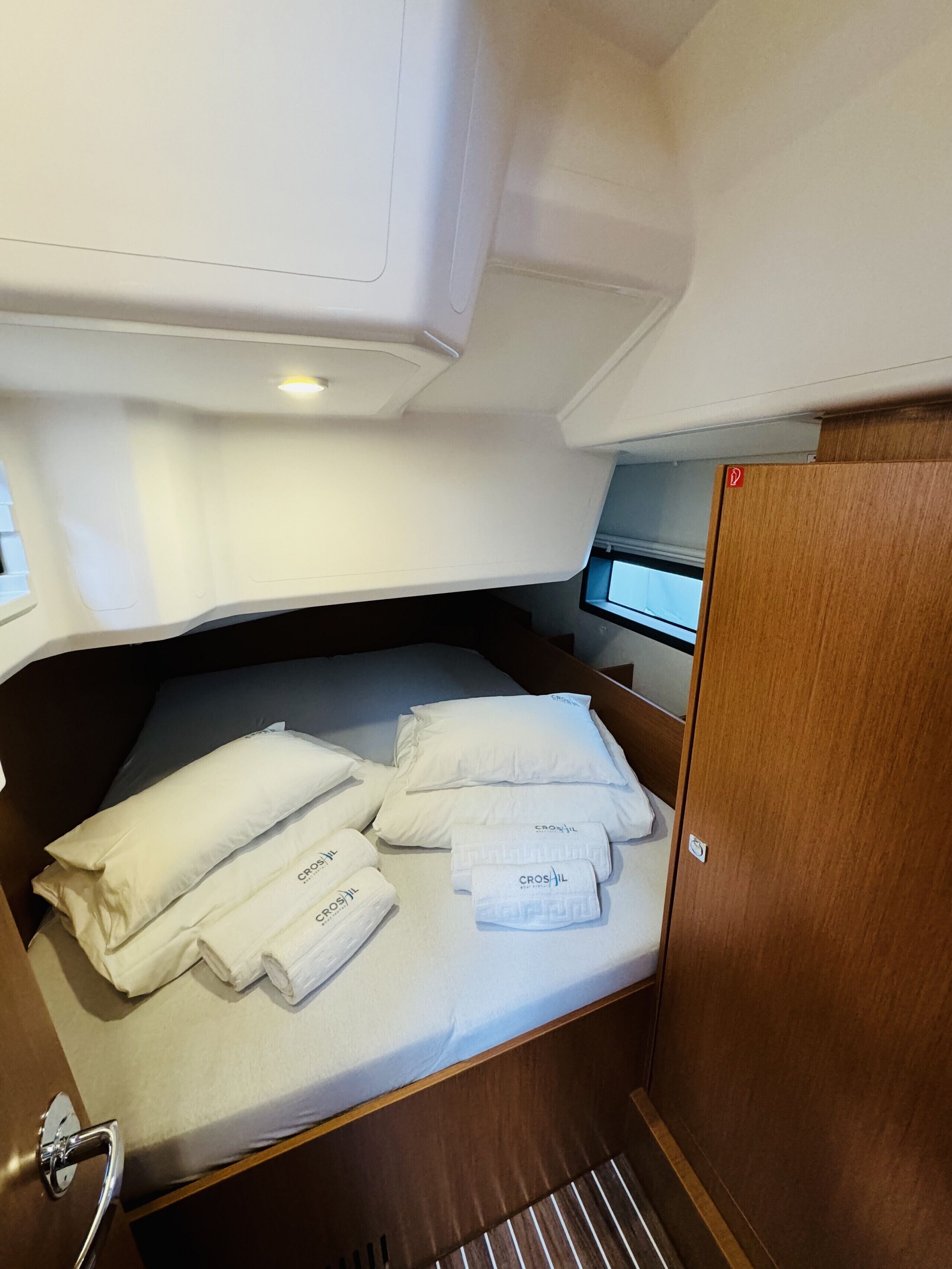 A compact cabin with a bed, a small table, and a wooden door.