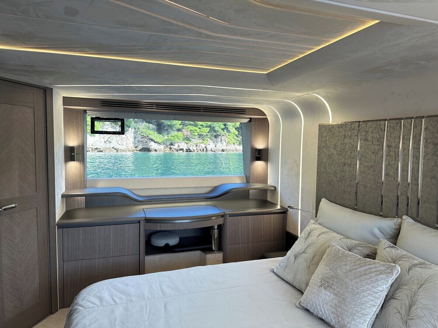 Un intérieur moderne avec un lit, un bureau et une vue sur une étendue d’eau.