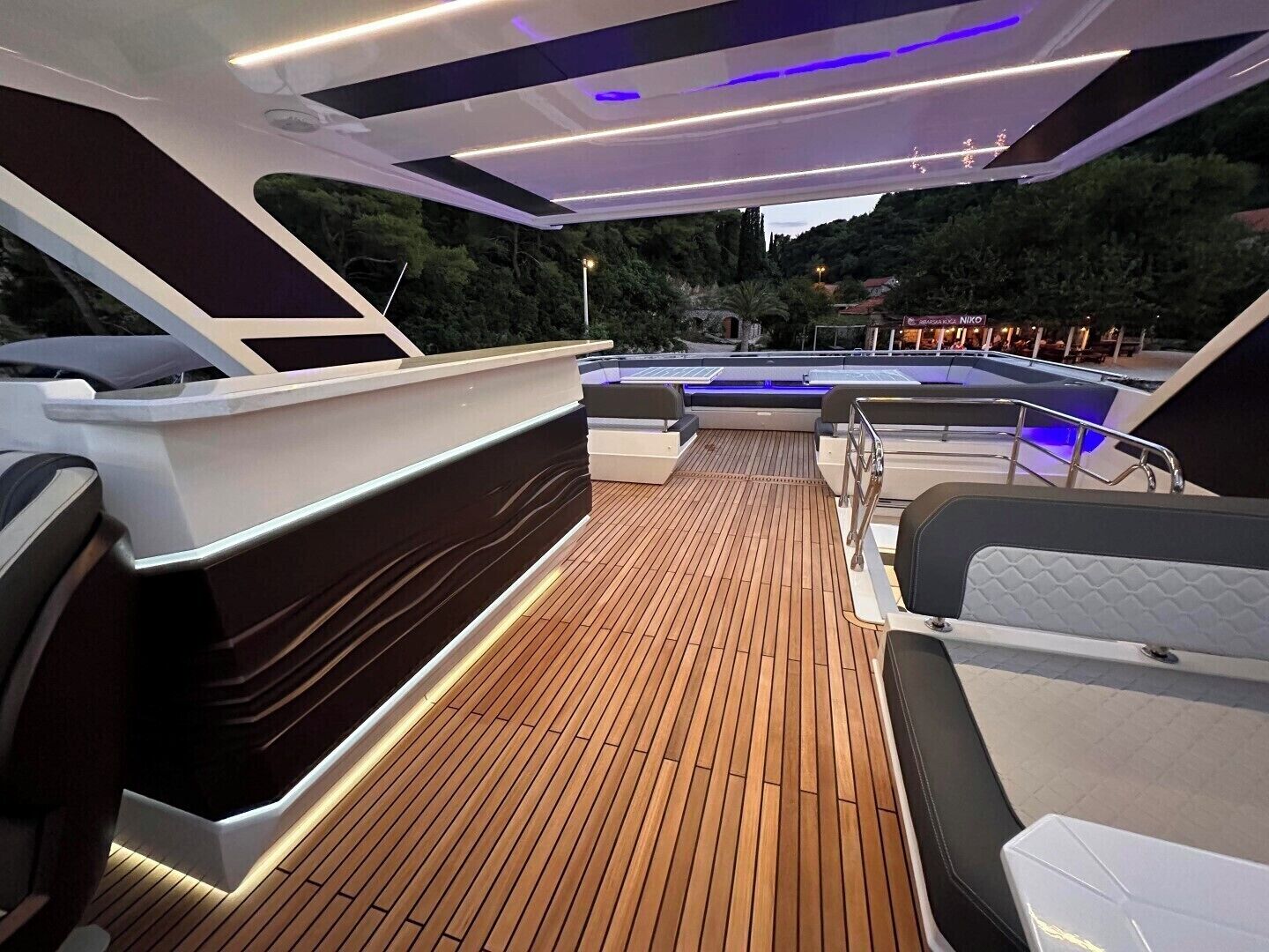 Le pont d’un yacht, avec des sièges, une piscine et une vue sur les environs.