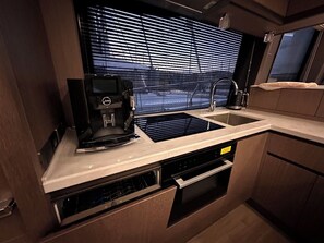 Uma cozinha compacta com cafeteira, pia e forno embutido.