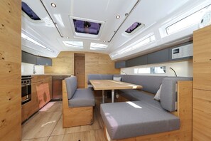 A compact interior with a kitchenette, a dining area, and seating. - Sun-Kissed Sailing Adventure in Zadar, Croatia (Biograd na moru)