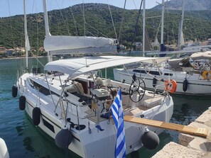Un yacht blanc était amarré dans une marina, avec une chaîne de montagnes en toile de fond.