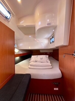A compact, well-lit interior with a bunk bed, a small seating area, and a control panel. - Sun-Kissed Sailing Adventure in Zadar, Croatia (Bibinje)