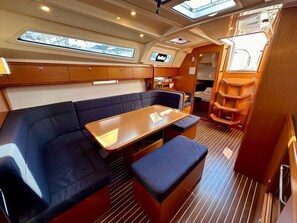 A compact interior with a sofa, a small table, and a TV screen. - Sun-Kissed Sailing Adventure in Zadar, Croatia (Bibinje)