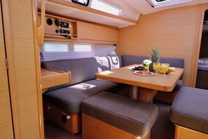 Ein kompaktes Wohnmobil-Interieur mit Essbereich, gepolsterten Sitzen und einer Küchenzeile.
