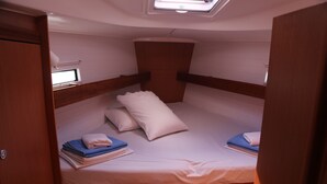 Ein kleines Häuschen mit einem Einzelbett, einer kleinen Sitzbank und einem Dachfenster.