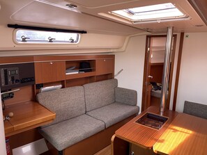 A compact RV interior with a kitchenette, a sofa, and a dining area.