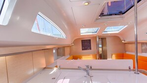 Ein modernes Interieur mit einer hellen Essecke, einem zentralen Tisch und Blick durch ein Fenster.