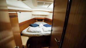 A compact cabin with a bed, a small seating area, and a ceiling with a skylight. - Sun-Kissed Sailing Adventure in the Sporades Islands from Volos, Thessaly (Volos)