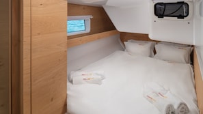 Ein gemütliches, kompakt eingerichtetes Blockhaus mit Etagenbett, kleinem Fenster und ordentlich gefalteten Handtüchern.