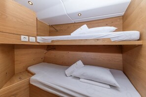 Una litera con ropa de cama blanca y detalles de madera.