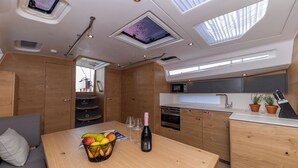 A compact kitchen with a microwave, oven, and wooden cabinets. - Sun-Kissed Sailing Adventure in Zadar, Croatia (Zadar)