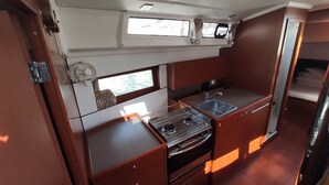 A compact galley with a stove, sink, and storage cabinets.