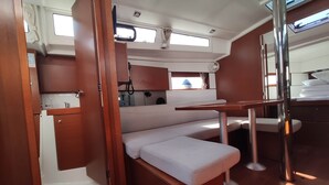 A compact galley with a kitchenette, a small seating area, and a window.