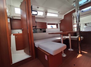 A compact galley with a kitchenette, a small seating area, and a window.