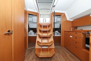 A narrow corridor with a central wooden structure, wooden cabinets, and a small window at the end. - Sibenik Sun-soaked Sailing: A Luxurious Croatian Voyage (Pirovac)