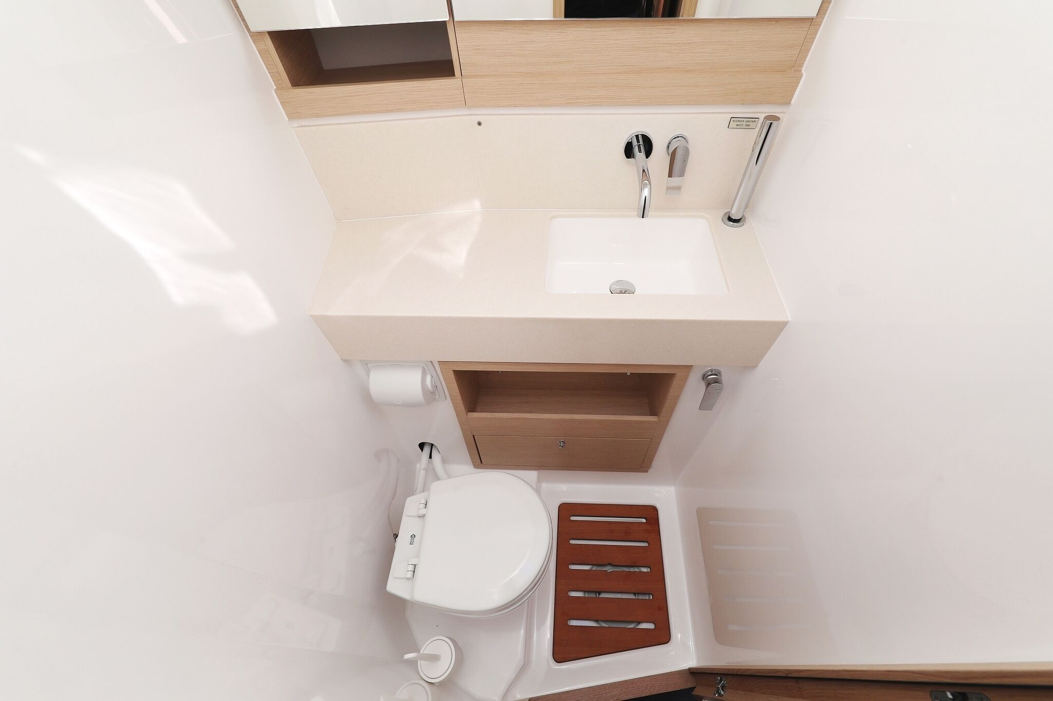 A compact bathroom with a toilet, sink, and shower area.