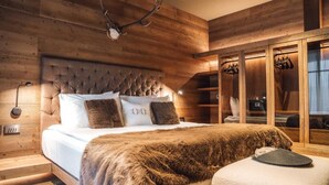 Un dormitorio con cabecera de madera, un plaid de piel y un perchero.