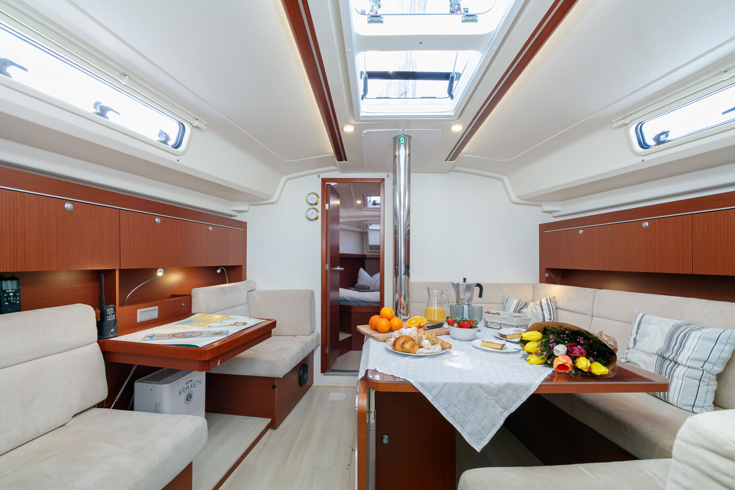 A compact interior with a dining area, a kitchenette, and a seating arrangement.